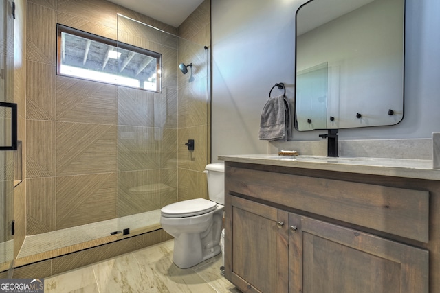 bathroom with vanity, toilet, and tiled shower