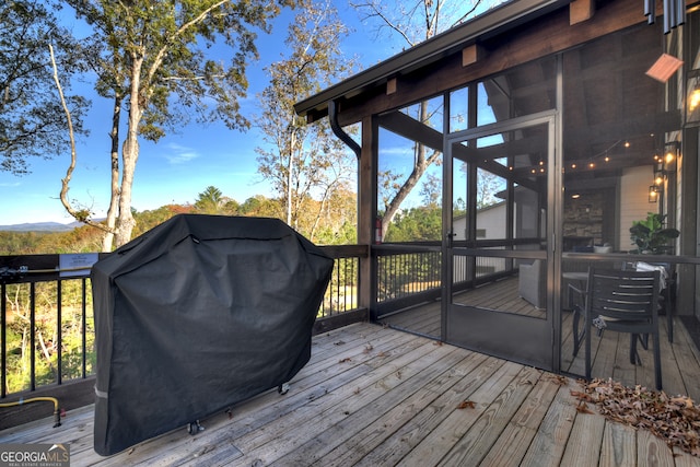 deck featuring a sunroom and grilling area