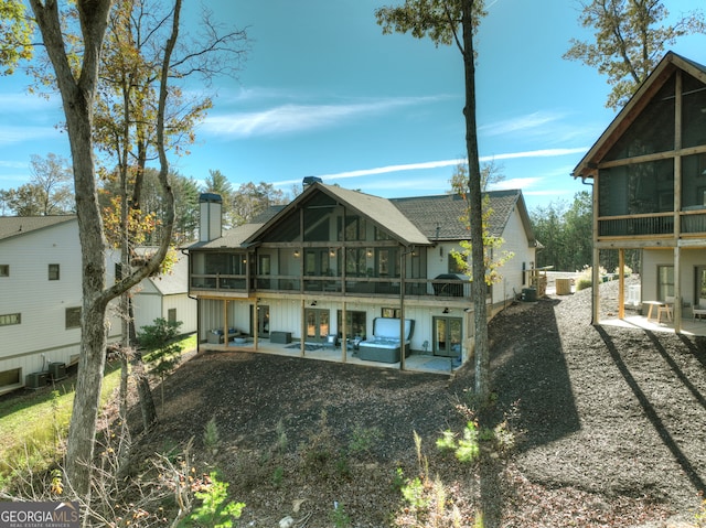 rear view of property with a patio area and a sunroom