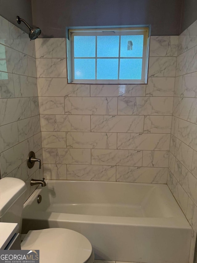 full bathroom featuring vanity, tiled shower / bath combo, and toilet