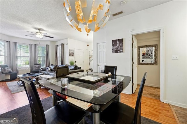 dining room with ceiling fan, a textured ceiling, and hardwood / wood-style flooring