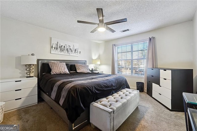 bedroom featuring a textured ceiling, carpet floors, and ceiling fan