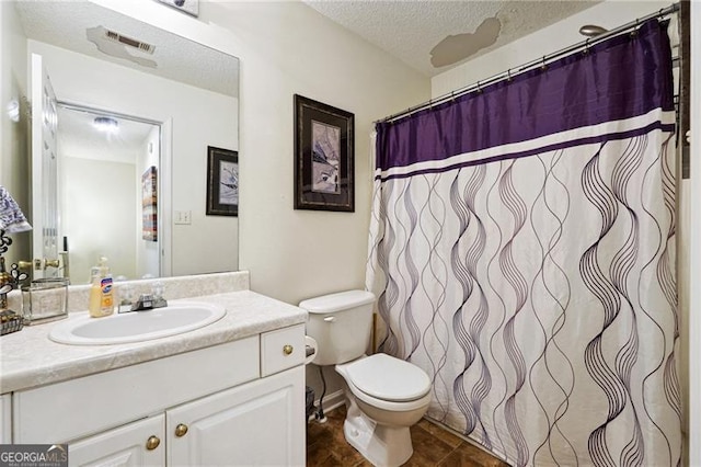 bathroom featuring tile patterned flooring, vanity, toilet, and a textured ceiling