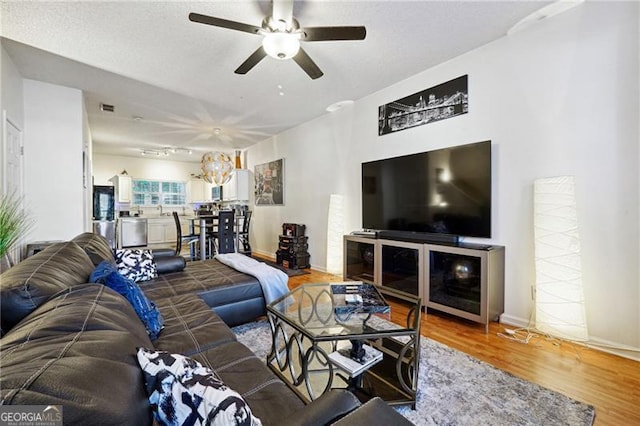 living room featuring ceiling fan and hardwood / wood-style flooring