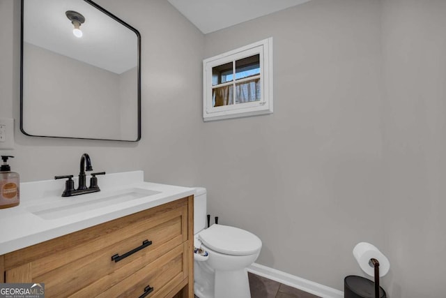 bathroom featuring tile patterned flooring, vanity, and toilet