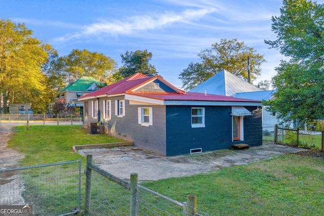 view of home's exterior with central air condition unit and a yard