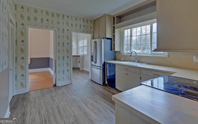 kitchen featuring sink, crown molding, dishwasher, stainless steel fridge with ice dispenser, and light wood-type flooring