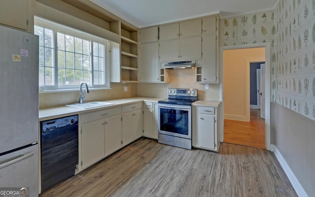 kitchen with appliances with stainless steel finishes, sink, and light wood-type flooring