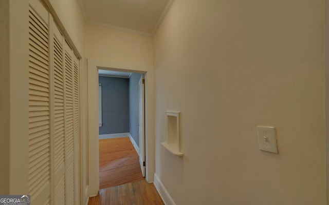 hall with hardwood / wood-style flooring and ornamental molding