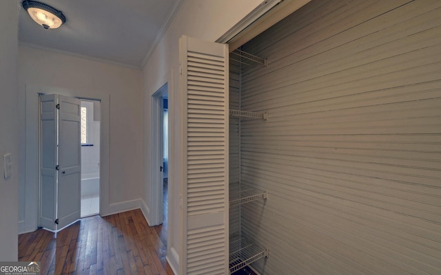 corridor with ornamental molding and dark hardwood / wood-style floors