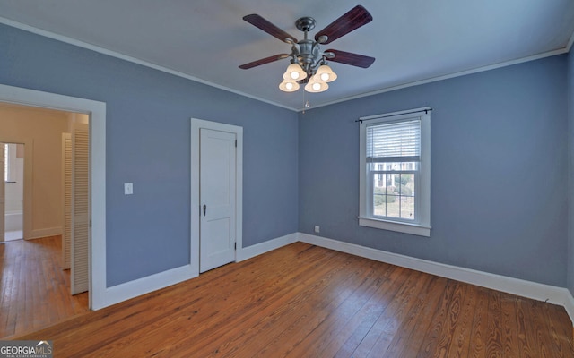 empty room with hardwood / wood-style flooring, ornamental molding, and ceiling fan