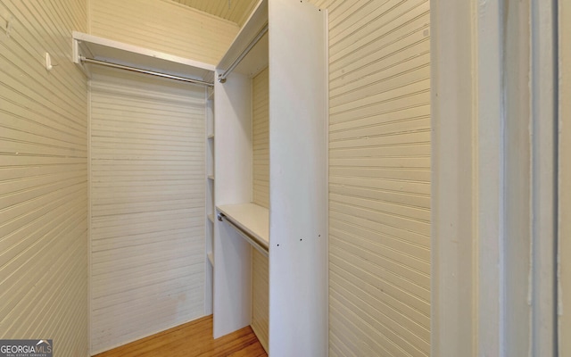 walk in closet with light hardwood / wood-style flooring