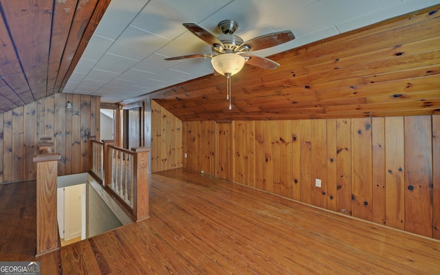 bonus room with wood-type flooring, vaulted ceiling, wooden ceiling, and wood walls