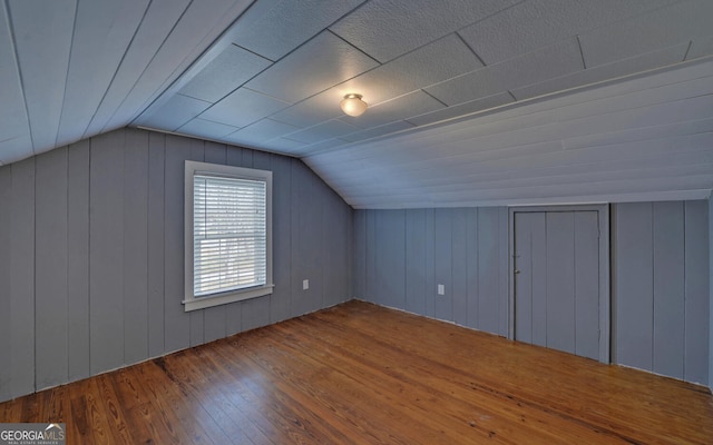 additional living space featuring wood-type flooring and lofted ceiling