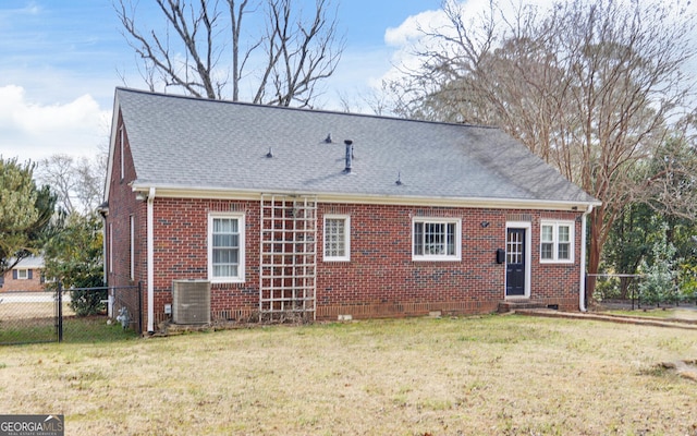 back of property featuring central air condition unit and a lawn