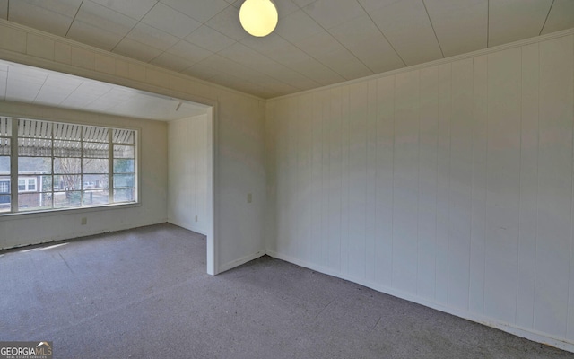 carpeted spare room featuring crown molding