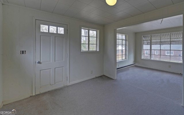 foyer entrance with a baseboard radiator and ornamental molding