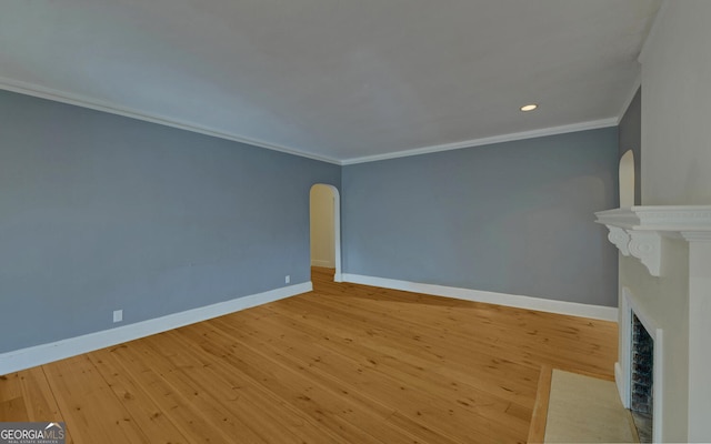 unfurnished living room with ornamental molding and light hardwood / wood-style floors