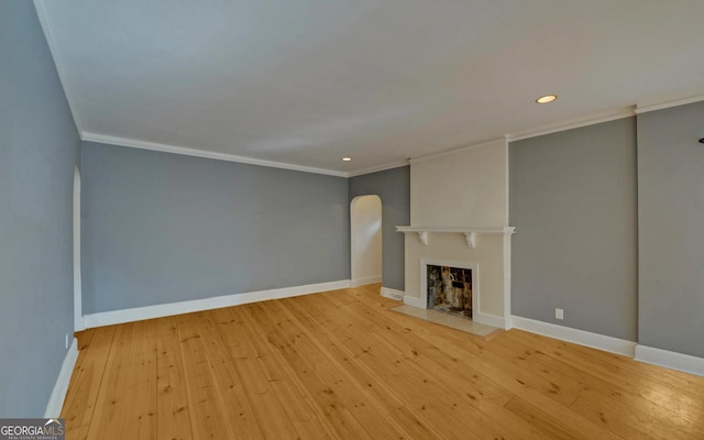 unfurnished living room featuring ornamental molding and light wood-type flooring