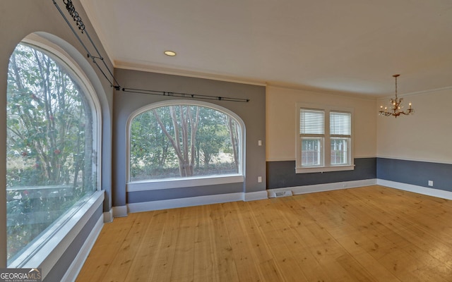 interior space with ornamental molding, a notable chandelier, and light hardwood / wood-style floors