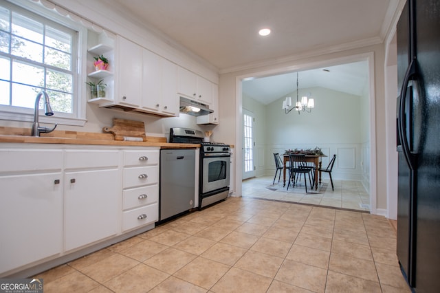 kitchen with pendant lighting, an inviting chandelier, appliances with stainless steel finishes, white cabinetry, and butcher block counters