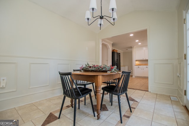 tiled dining space with a notable chandelier and vaulted ceiling