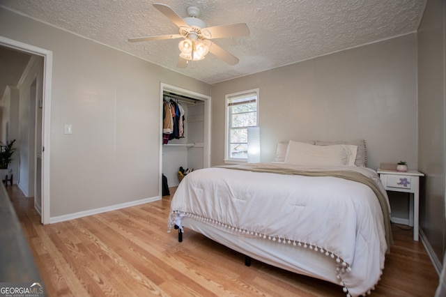 bedroom with hardwood / wood-style floors, a textured ceiling, a closet, and ceiling fan