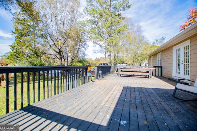 deck featuring a lawn and french doors