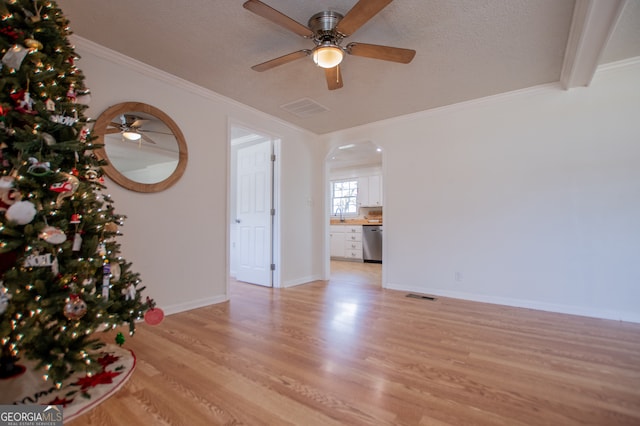 empty room with a textured ceiling, light hardwood / wood-style flooring, ceiling fan, and sink