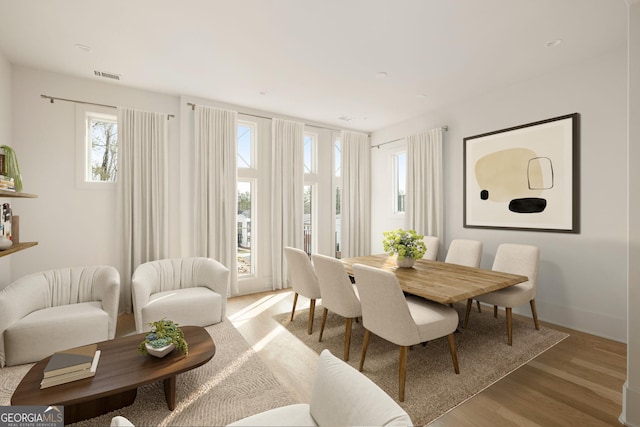 dining space featuring baseboards, visible vents, and wood finished floors