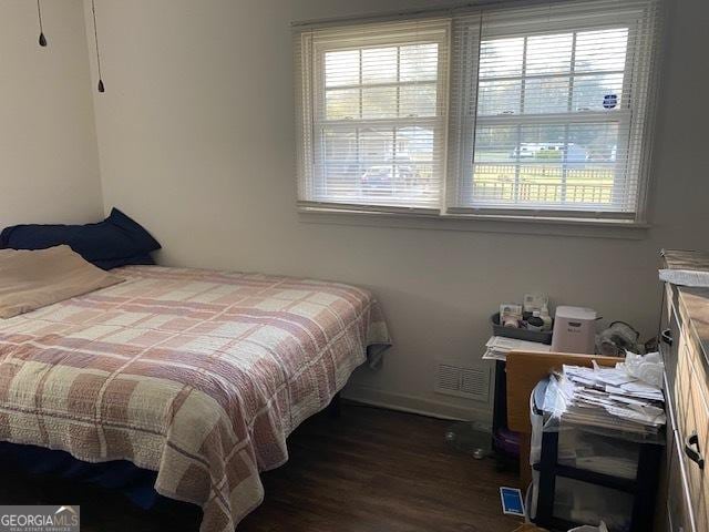 bedroom with dark hardwood / wood-style flooring