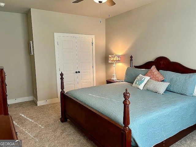 carpeted bedroom featuring ceiling fan and a closet