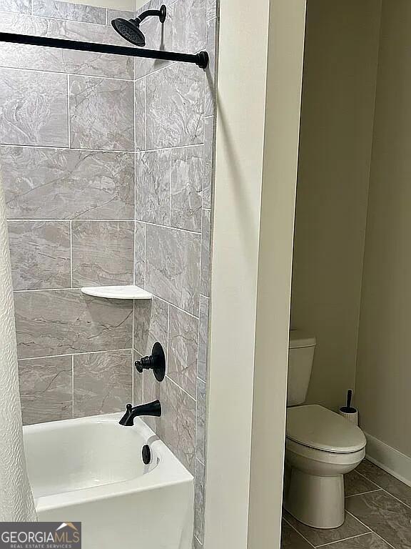 bathroom featuring tiled shower / bath and toilet