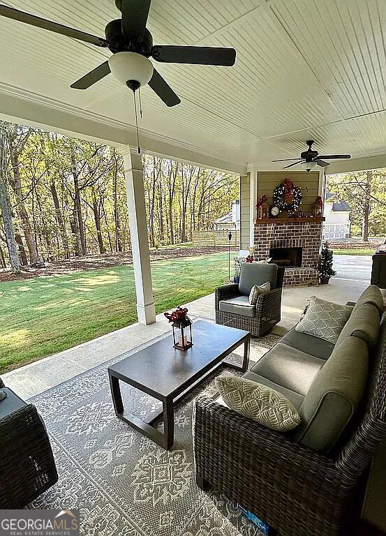 view of patio / terrace with an outdoor living space with a fireplace