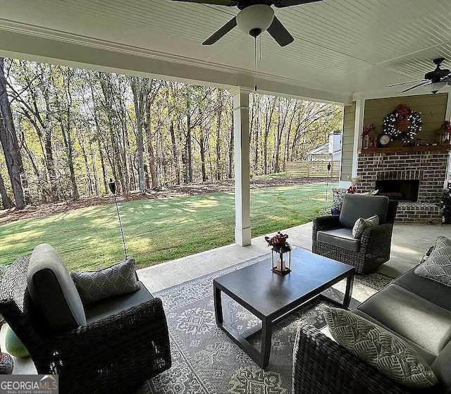 view of patio with an outdoor living space with a fireplace and ceiling fan