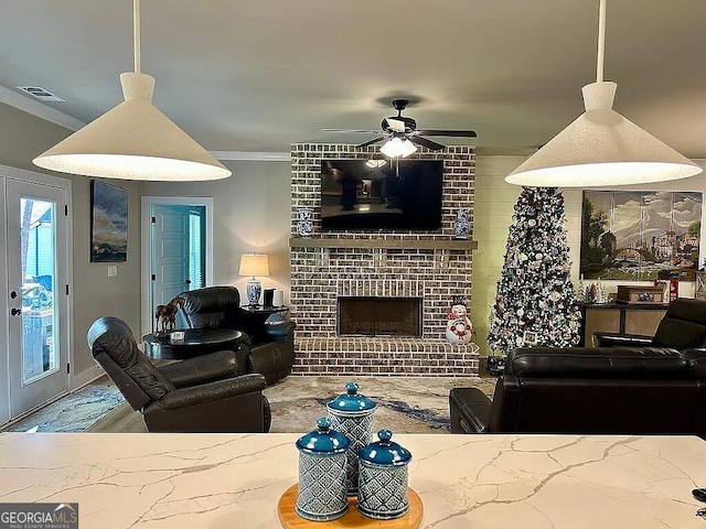 living room featuring ceiling fan, ornamental molding, and a brick fireplace