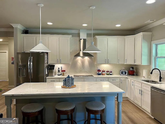 kitchen with sink, a center island, stainless steel dishwasher, refrigerator with ice dispenser, and decorative light fixtures