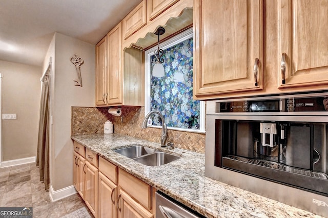 kitchen with backsplash, light stone countertops, sink, and light brown cabinets