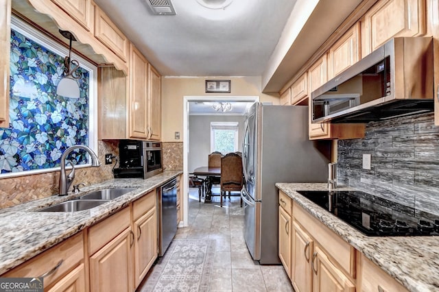 kitchen with light brown cabinets, sink, appliances with stainless steel finishes, and tasteful backsplash