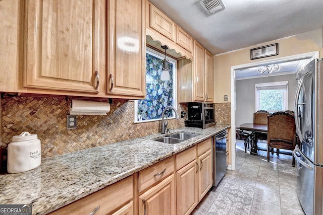 kitchen with light stone counters, sink, stainless steel appliances, and light brown cabinetry