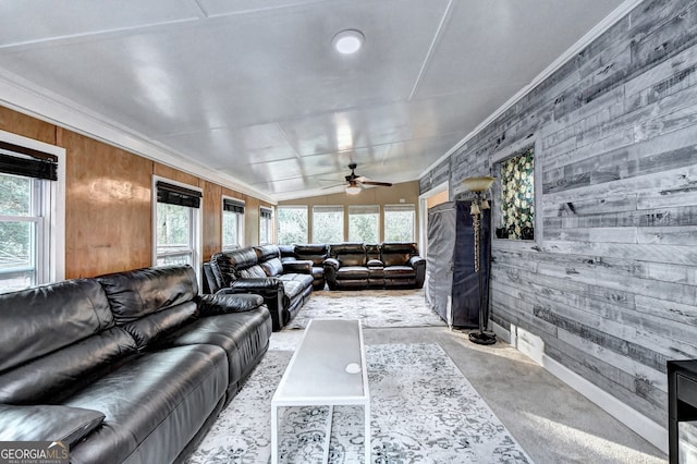 carpeted living room featuring plenty of natural light, crown molding, wooden walls, and vaulted ceiling