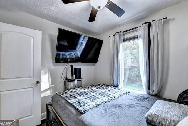 bedroom featuring ceiling fan and a textured ceiling