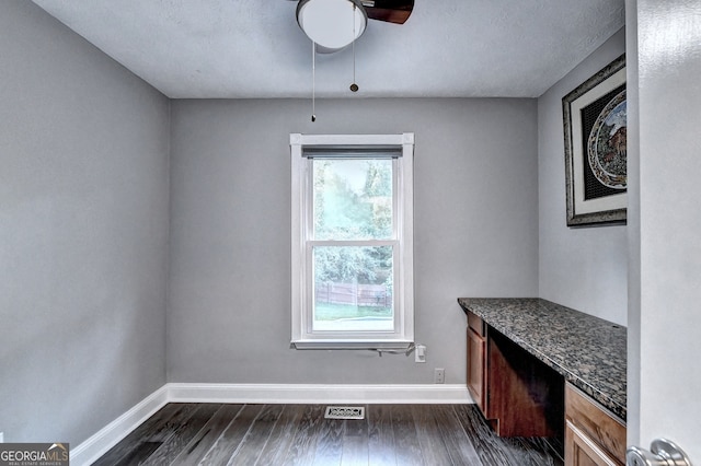 interior space with a textured ceiling, dark hardwood / wood-style flooring, and ceiling fan