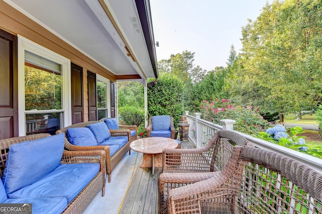 wooden terrace with an outdoor living space