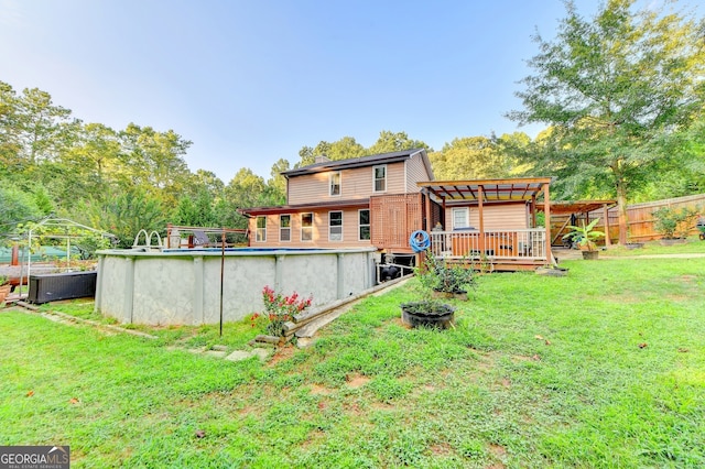 back of house with a pergola, a lawn, and a pool side deck