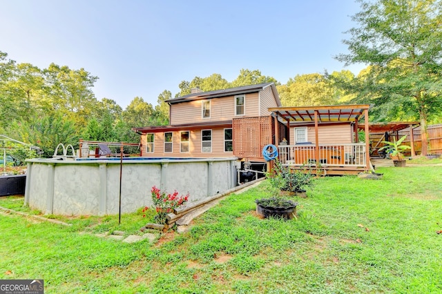 back of house featuring a pergola, a swimming pool side deck, and a yard