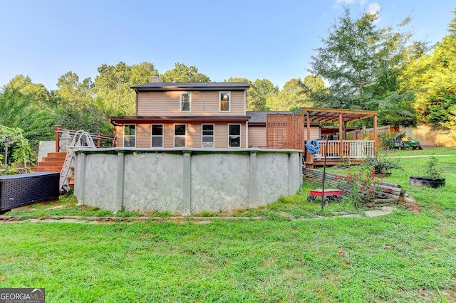 back of property featuring a lawn, a pergola, and a swimming pool side deck