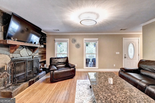 living room with a fireplace, crown molding, and hardwood / wood-style floors