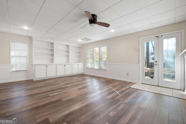 spare room featuring ceiling fan, french doors, built in features, dark hardwood / wood-style floors, and a paneled ceiling