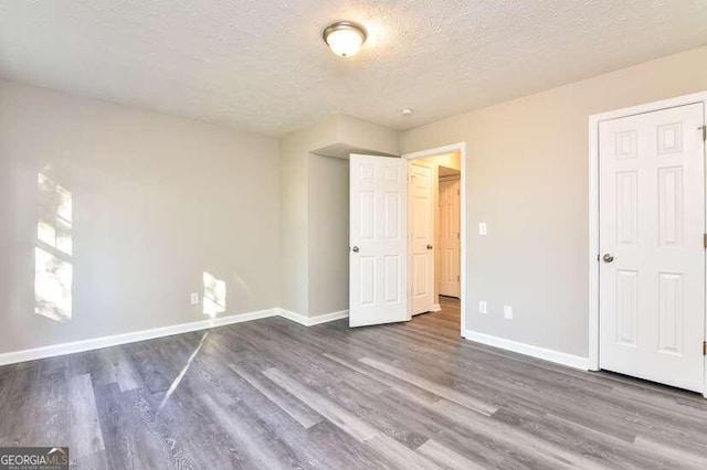 unfurnished bedroom with hardwood / wood-style flooring and a textured ceiling